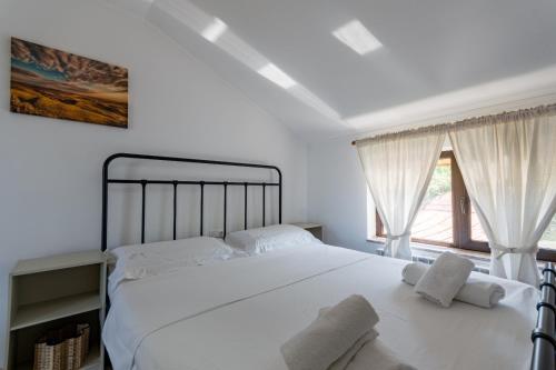 a bedroom with a large white bed with white sheets at Casa Haralambie in Greci