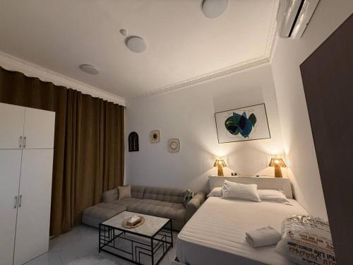 a bedroom with a bed and a couch at Single room Jimi in Al Ain