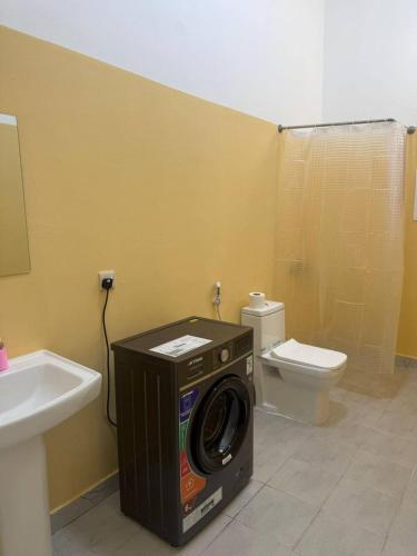 a washing machine in a bathroom with a toilet at Single room Jimi in Al Ain