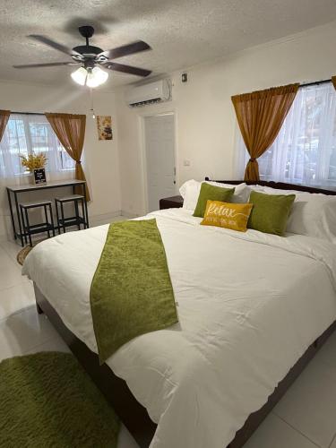 a bedroom with a large white bed with a ceiling fan at Your Blooming Getaway in Nassau