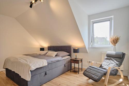 a bedroom with a bed and a chair and a window at Ferienwohnung 12 Monkeys in Stuhr