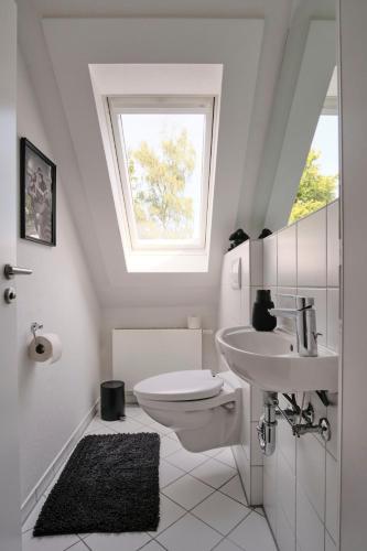 a bathroom with a toilet and a sink and a window at Ferienwohnung 12 Monkeys in Stuhr