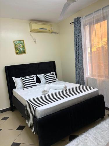 a large bed in a bedroom with a window at Terry's 2br sunsweet resort shanzu,mombasa in Mombasa