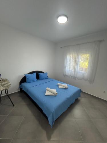 a bedroom with a blue bed with two towels on it at Apartment Petar in Kotor