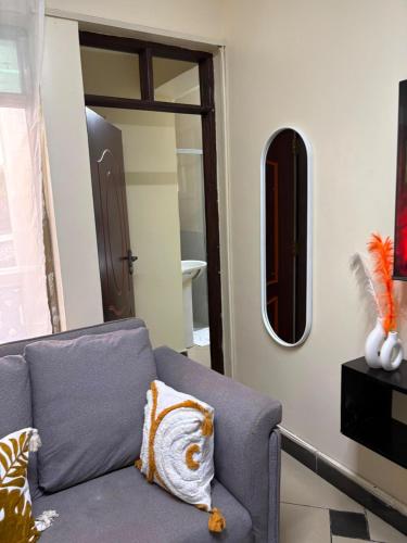 a living room with a couch and a mirror at Terry's 2br sunsweet resort shanzu,mombasa in Mombasa