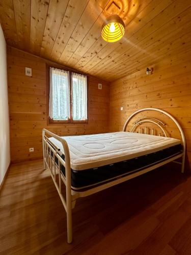 a bedroom with a bed in a wooden room at Appartement L'argentiere la bessée in LʼArgentière-la-Bessée