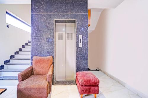 a living room with a chair and stairs at Super Townhouse LIG Main Road Indore in Indore