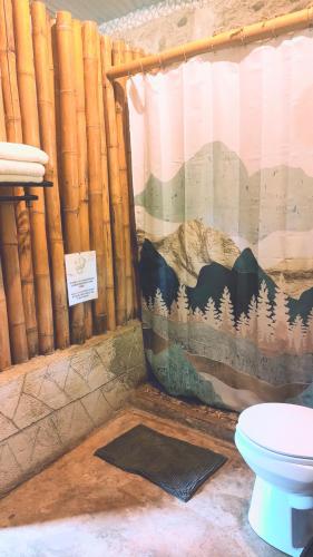 ein Badezimmer mit Toilette und Duschvorhang in der Unterkunft Cabañas Ixaya in Catemaco
