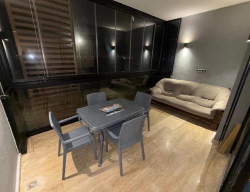 a living room with a table and chairs and a couch at Appartement Sidi Rahal Oceanic in Sidi Rahal