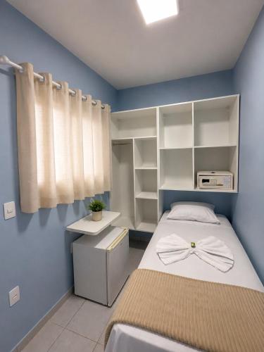 a small bedroom with a bed and a window at Pousada Ocean Mare in Praia do Frances