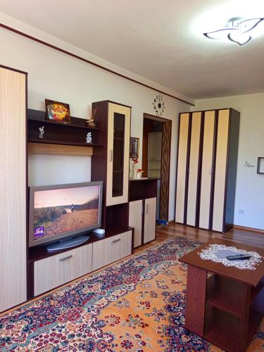 a living room with a flat screen tv and a table at Modern Beach Apartment in Constanţa