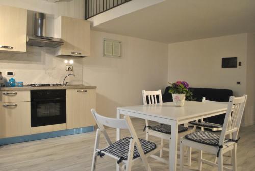 cocina y comedor con mesa blanca y sillas en Smart Central Apartments San Gregorio, en Nápoles