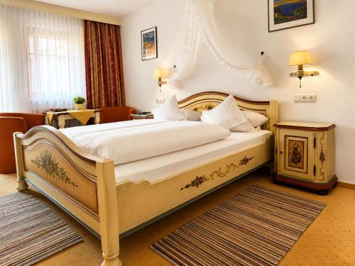 a hotel room with a large bed and a table at Hotel Tilman Riemenschneider by ANS in Rothenburg ob der Tauber