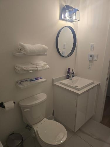 a bathroom with a toilet and a sink and a mirror at TeeBams's Comfy Home in Riverview