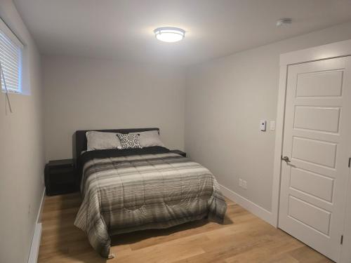 a bedroom with a bed in a white room at TeeBams's Comfy Home in Riverview
