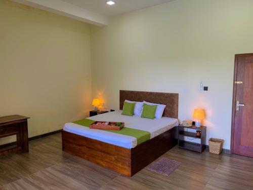 a bedroom with a large bed with green pillows at Ruchi Villa in Wadduwa