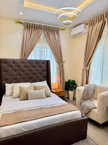 a bedroom with a large bed and a chair at Haven 21 in Aja