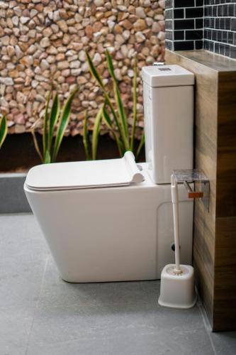 a white toilet sitting in front of a wall at Ruchi Villa in Wadduwa
