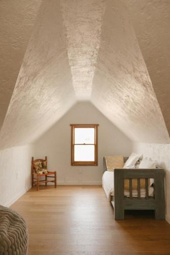 a attic room with a bed and a window at El Ranchito Alegre Private 3BR Home in Historic Corrales in Corrales