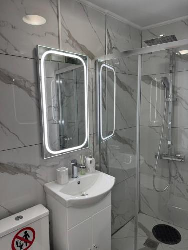 a white bathroom with a sink and a mirror at Modern studio in Athens