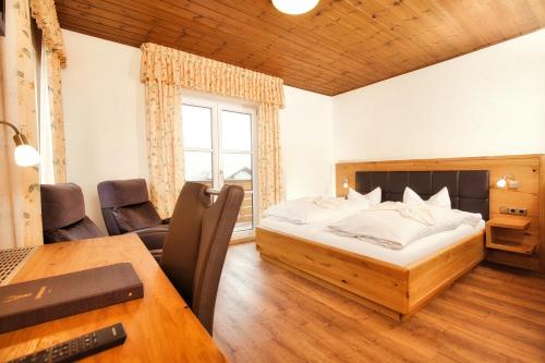 a bedroom with a bed and a desk and a table at Der Glaserhof - WaldZeitHotel in Lam