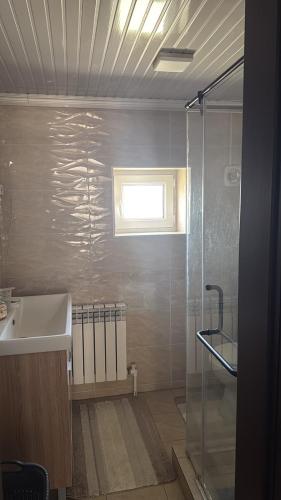 a bathroom with a shower and a sink and a window at Family Villa in Osh
