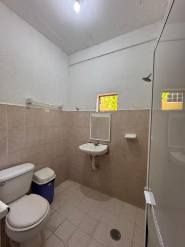 a bathroom with a toilet and a sink at Casa Santa Elena in Brisas de Zicatela