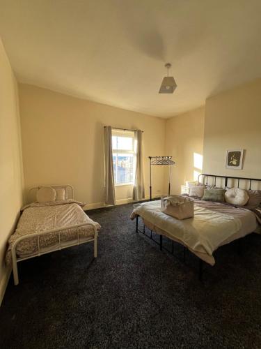 a bedroom with two beds and a window at The Blackburn 2 Bedroom House in Cherry Tree