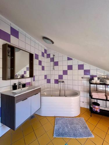 a bathroom with a tub and a sink and a mirror at Villa Kiki in Bol