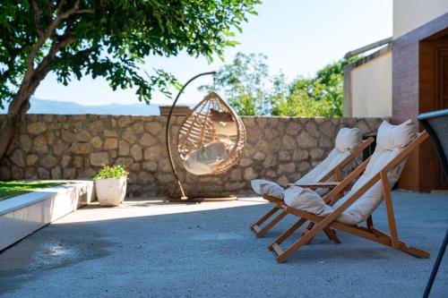 a teddy bear sitting in a rocking chair on a patio at Luna Pool Apartment in Danilovgrad