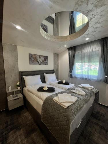 a bedroom with a large bed and a large mirror at Ambasada Rooms in Sarajevo
