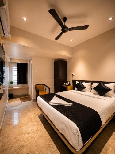 a bedroom with a large bed with a ceiling fan at Hajiyar Residency in Rāmanāthapuram
