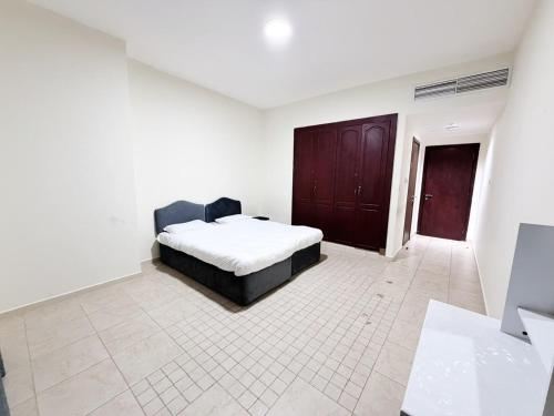 ein Schlafzimmer mit einem Bett in einem weißen Zimmer in der Unterkunft Rose Building in Dubai