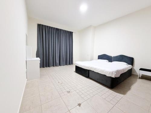 ein weißes Schlafzimmer mit einem Bett und einem Fenster in der Unterkunft Rose Building in Dubai