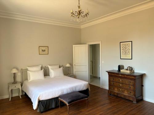 a bedroom with a bed and a dresser and a chandelier at Château Saint Georges in Mauléon