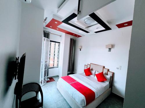 a bedroom with a bed with red pillows in it at Comfort Deluxe Apart in Kigali