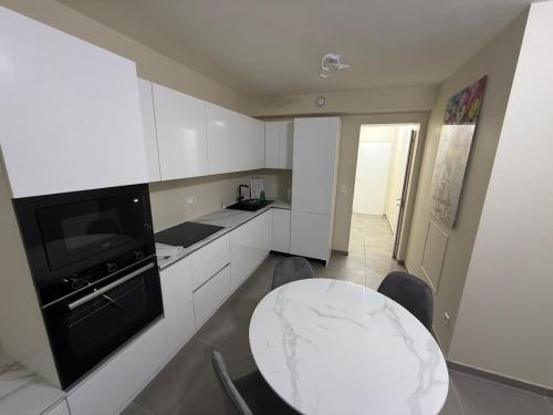 a white kitchen with a table and a counter top at The Eight in Luxembourg