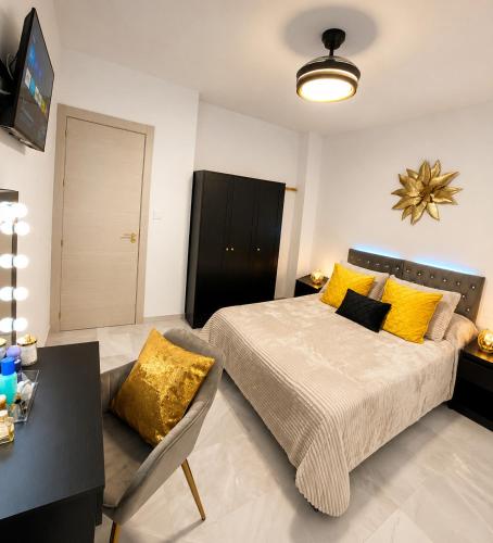 ein Schlafzimmer mit einem Bett mit gelben Kissen in der Unterkunft Lanja Suites in Lanjarón