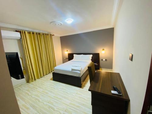a hotel room with a bed and a desk at Snl Mountain View Hotel in Oko Sombo