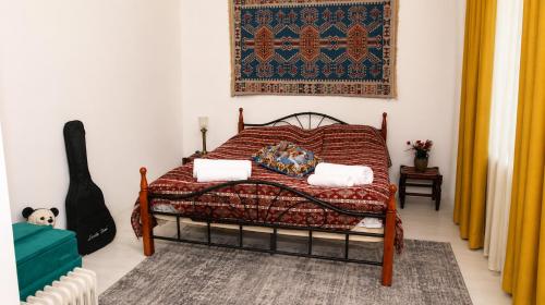 a bedroom with a bed and a rug and a guitar at Guest House in Sanahin in Sanain