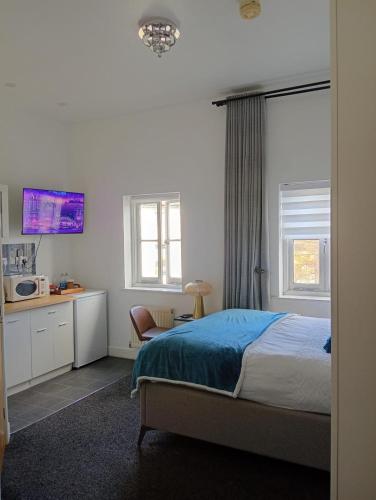 a bedroom with a bed and a desk and a microwave at Precise Homes in Wolverhampton