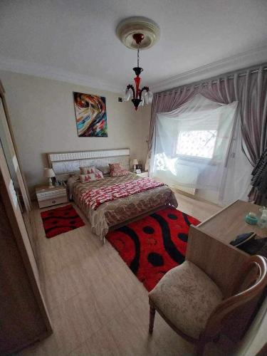 a bedroom with a bed and a chair and a window at Yamina's Holiday in Raoued
