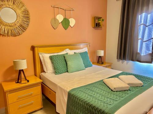 a bedroom with a bed with green sheets and pillows at Edifício Barão Filippi in Águas de Lindoia