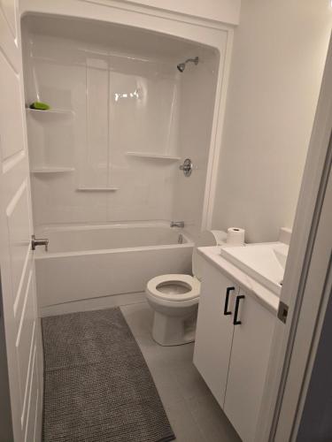 a white bathroom with a toilet and a sink at Private Guest Suite Sleeps 4 in Riverview