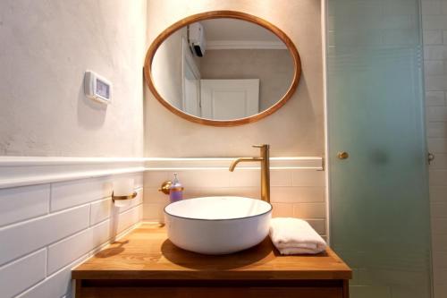 a bathroom with a bowl sink and a mirror at Migdalor apartments Tiberias in Tiberias