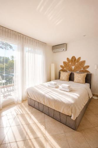 a bedroom with a large bed and a large window at Cap et Soleil Peaceful Private Garden, 2 Terraces, Pool, Garage, 5 Min Walk to Beach in Antibes