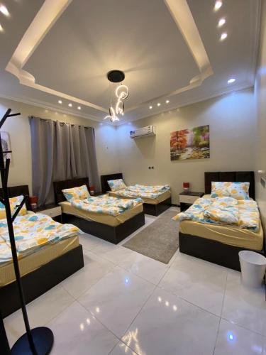 a room with four beds in a room with a ceiling at Abha Jacaranda in Abha