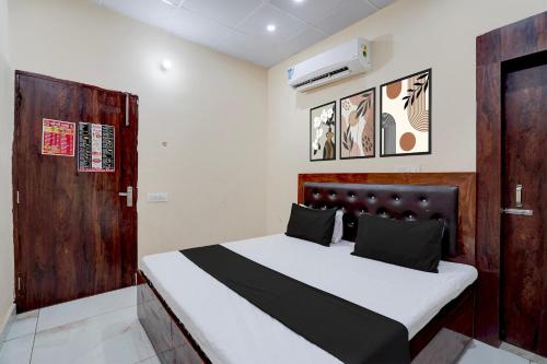 a bedroom with a bed and a wooden door at Hotel O Star Light in Rohtak