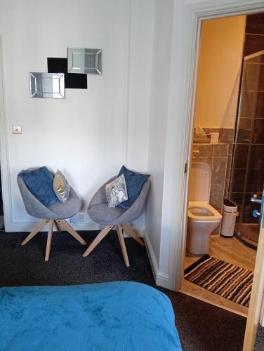 a bathroom with two chairs and a toilet at Precise Homes in Wolverhampton