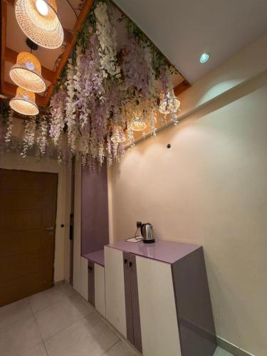 a room with a table with flowers hanging from the ceiling at Aureva stays Omaxe Hazratganj in Nalmatha